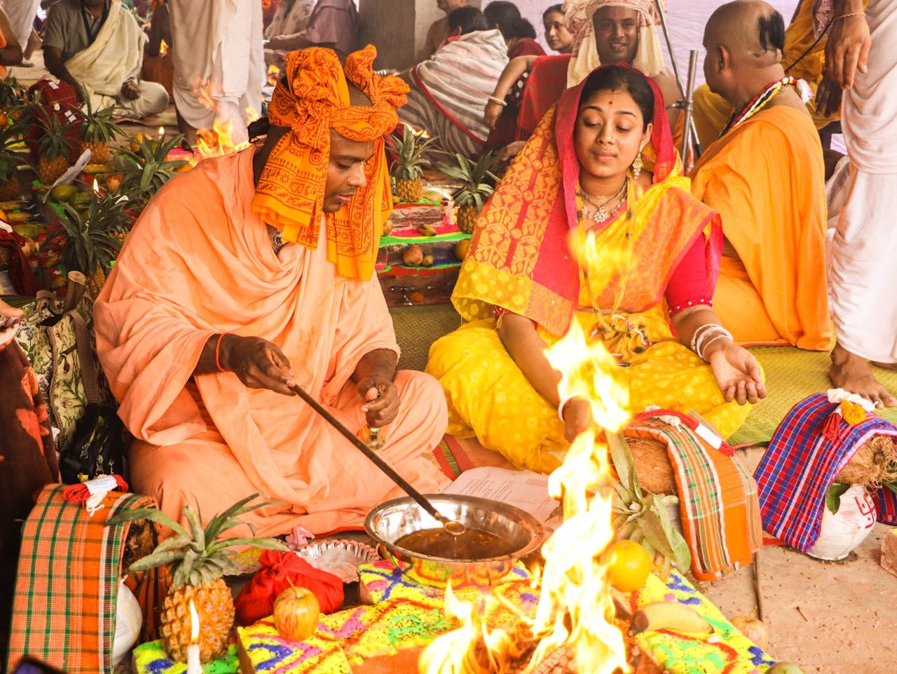 Pandit performing sacred fire ceremony with traditional ritual materials
